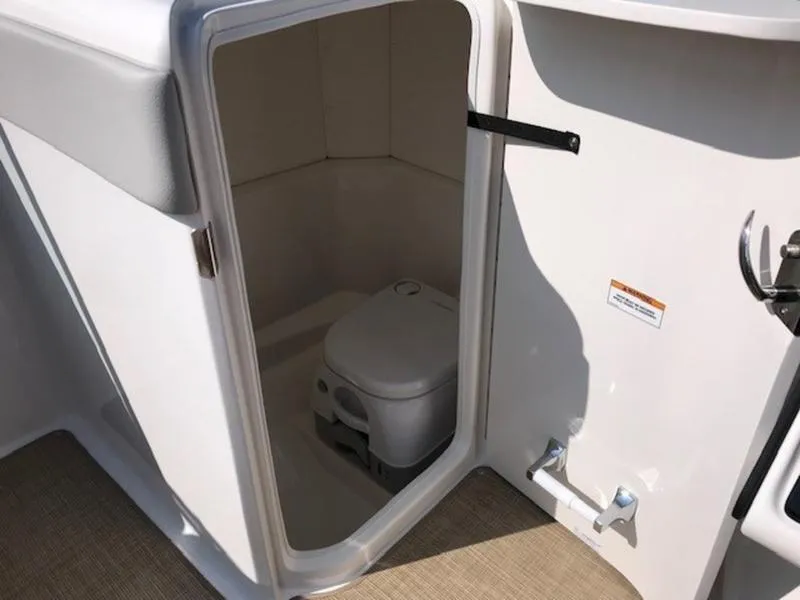 Slide: The Image of 2024 Sea Ray 230 SPX boat interior with compact marine toilet. - 6