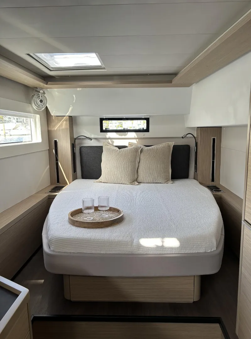 Slide: The Image of 2024 Lagoon 46 yacht with a Honda outboard motor, docked in a marina. - 27