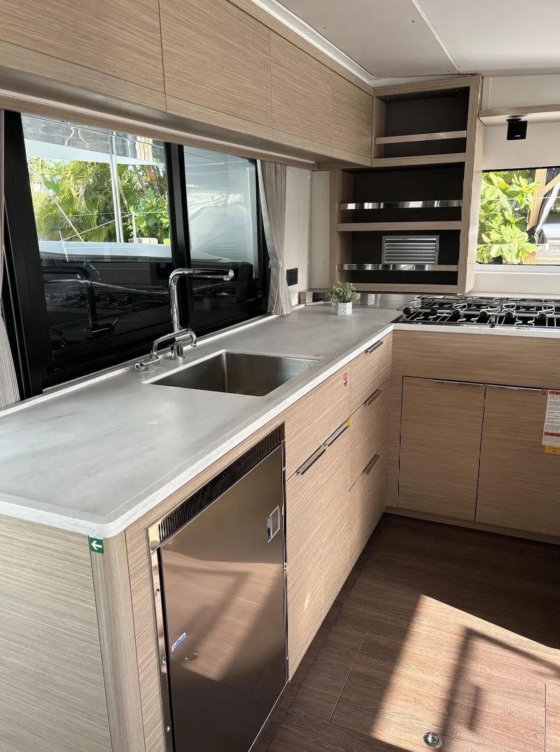 Slide: The Image of 2024 Lagoon 46 yacht interior with modern kitchen and navigation station. - 34