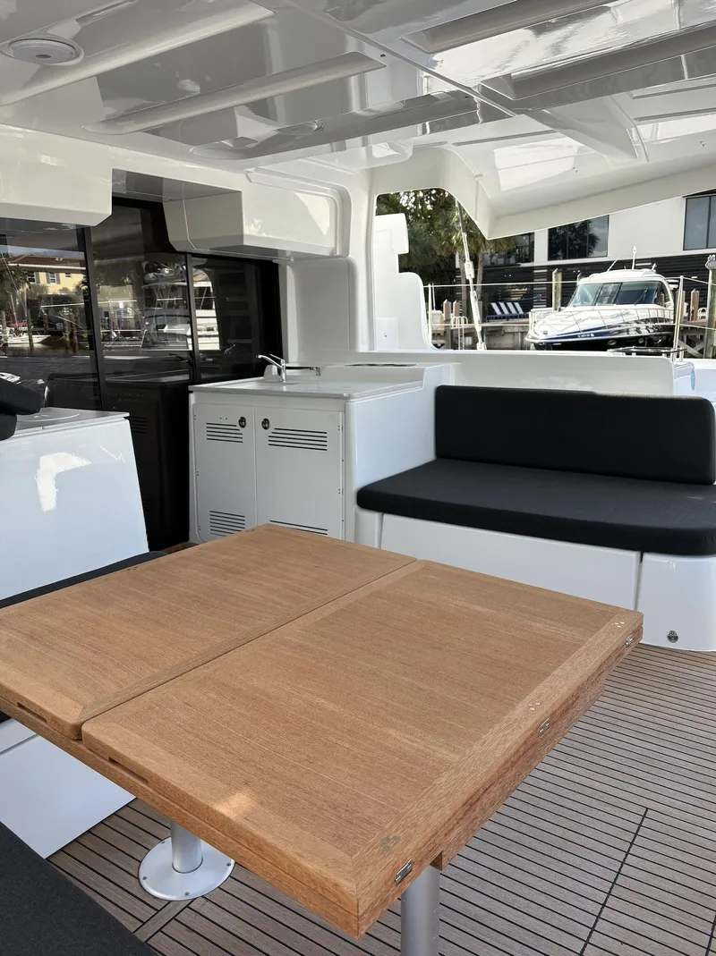 Slide: The Image of 2024 Lagoon 46 yacht with spacious deck and modern amenities, docked in a marina. - 38