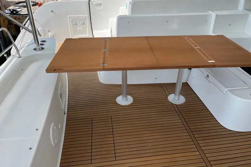 Slide: The Image of 2024 Lagoon 46 yacht cockpit with wooden table and sleek design. - 50