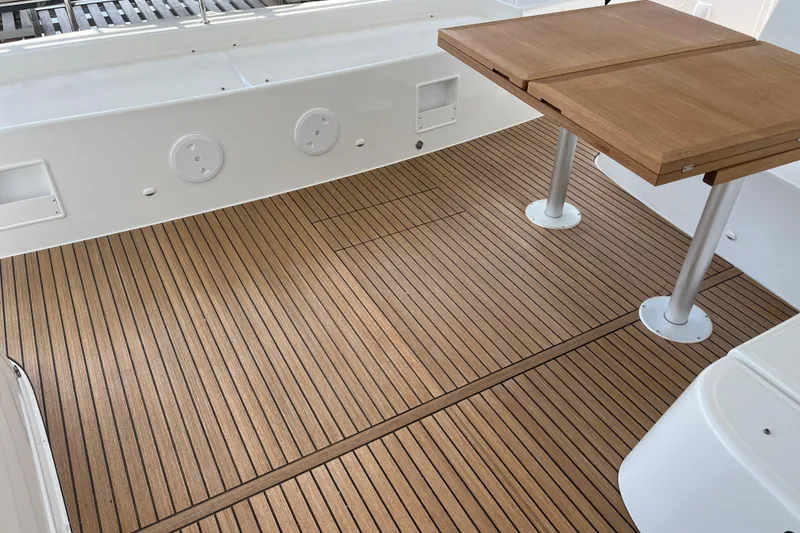 Slide: The Image of 2024 Lagoon 46 yacht deck with wooden flooring and foldable table. - 51
