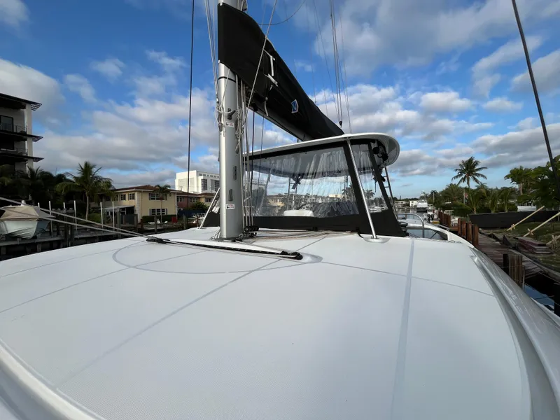Slide: The Image of 2024 Lagoon 46 catamaran with spacious deck seating at a marina. - 9