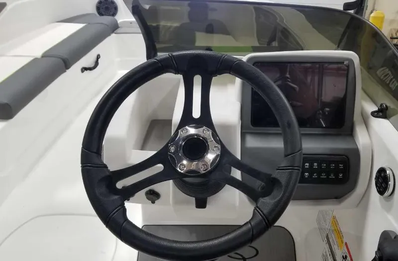 Slide: The Image of 2024 Tahoe T21 boat on trailer, white with green accents, parked on grass. - 4