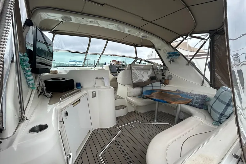 Slide: The Image of 2000 Cruisers Yachts 3870 Express interior with seating, table, and helm station. - 11
