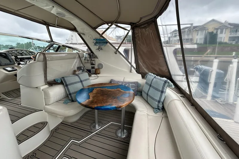 Slide: The Image of 2000 Cruisers Yachts 3870 Express interior with plush seating and custom wood table. - 24