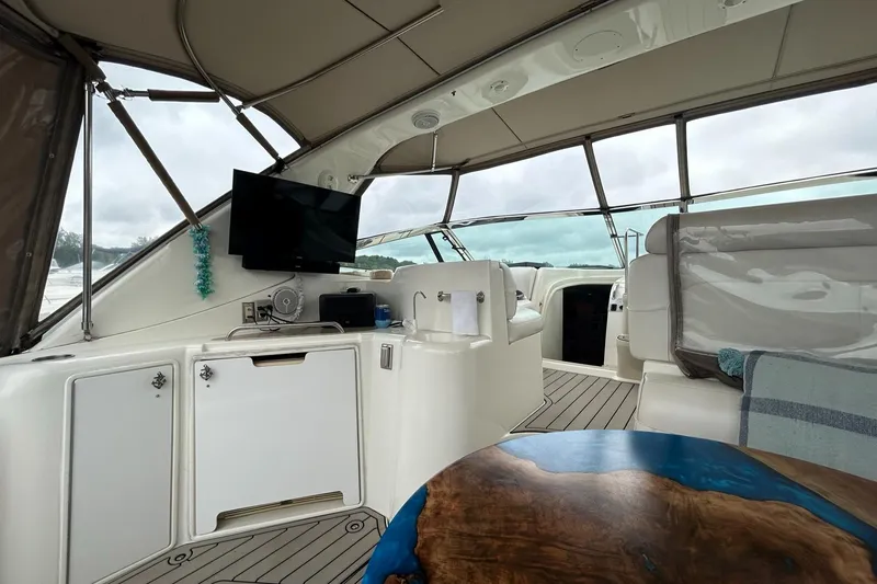 Slide: The Image of Interior of 2000 Cruisers Yachts 3870 Express with TV, seating, and wooden table. - 28
