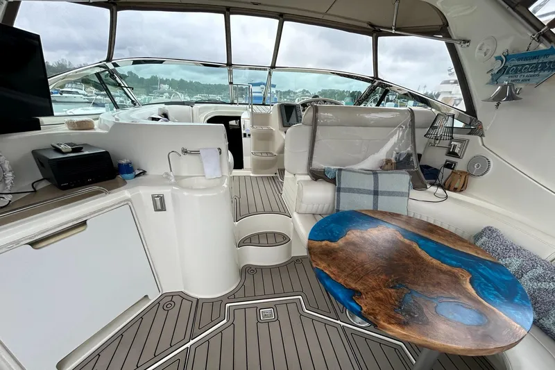 Slide: The Image of Interior of 2000 Cruisers Yachts 3870 Express with modern amenities and unique wooden table. - 29
