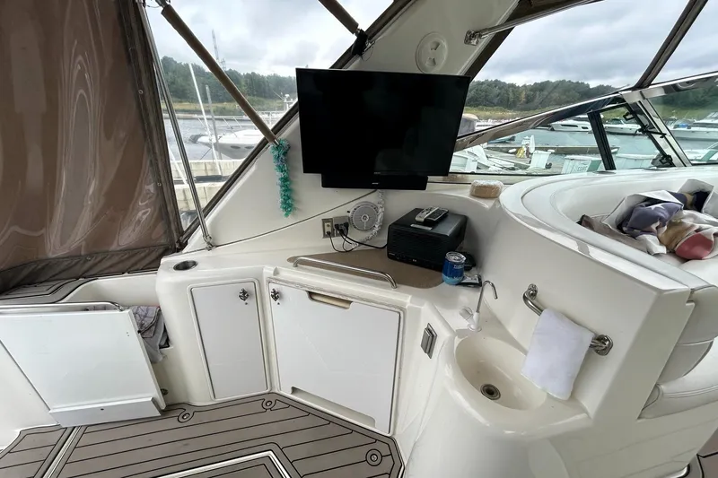 Slide: The Image of 2000 Cruisers Yachts 3870 Express cockpit with TV, sink, and storage cabinets. - 30
