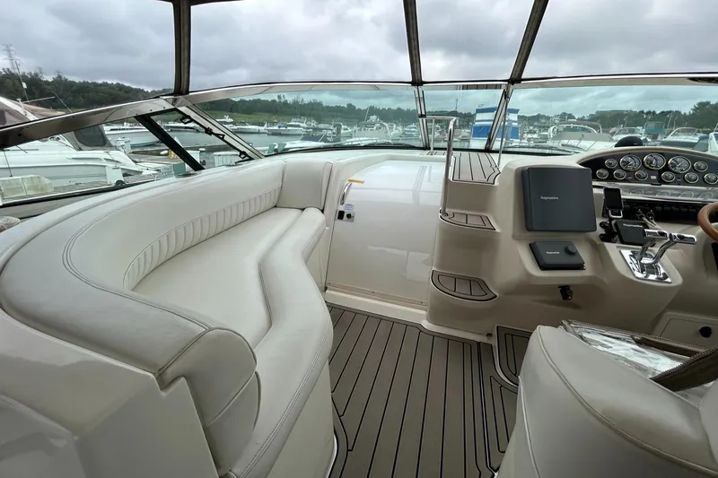 Slide: The Image of 2000 Cruisers Yachts 3870 Express cockpit with white leather seating and control panel. - 32