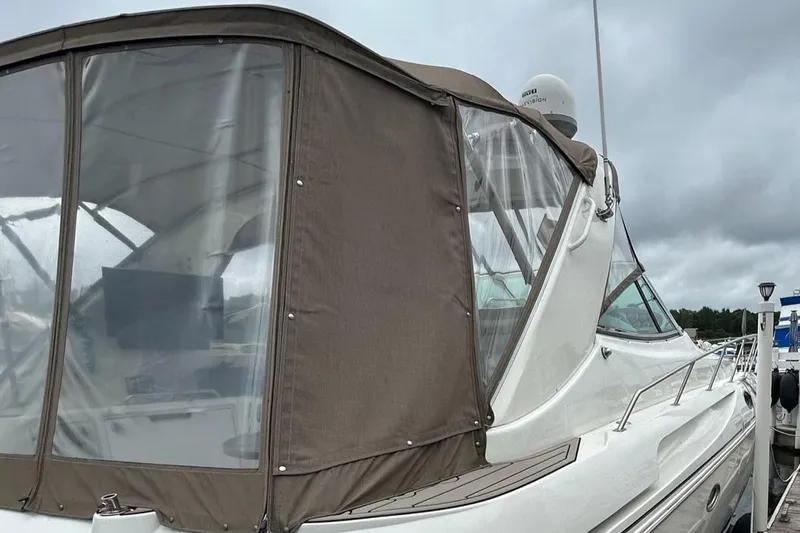 Slide: The Image of 2000 Cruisers Yachts 3870 Express with brown canvas enclosure at a marina. - 45