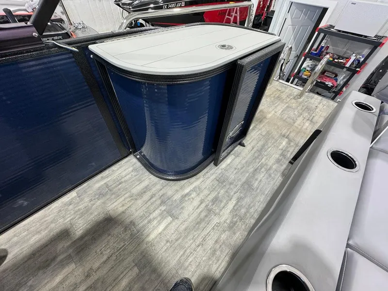 Slide: The Image of 2023 Crest Classic Platinum 220 boat interior with sleek blue paneling and modern seating. - 14