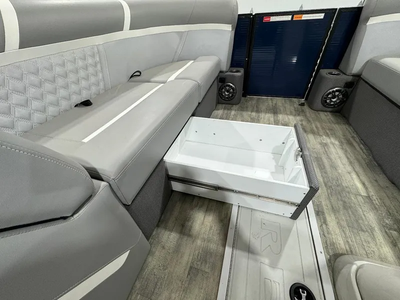 Slide: The Image of 2023 Crest Classic Platinum 220 interior with gray seating and open storage drawer. - 18