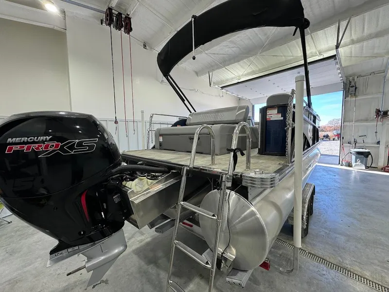 Slide: The Image of 2023 Crest Classic Platinum 220 pontoon boat with Mercury Pro XS engine in a garage. - 3