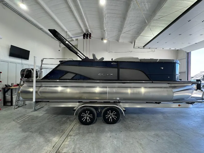 Slide: The Image of 2023 Crest Classic Platinum 220 pontoon boat in a spacious indoor showroom. - 4