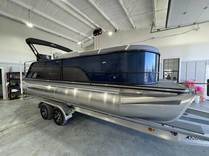 Slide: The Image of 2023 Crest Classic Platinum 220 pontoon boat on trailer in a garage setting. - 5