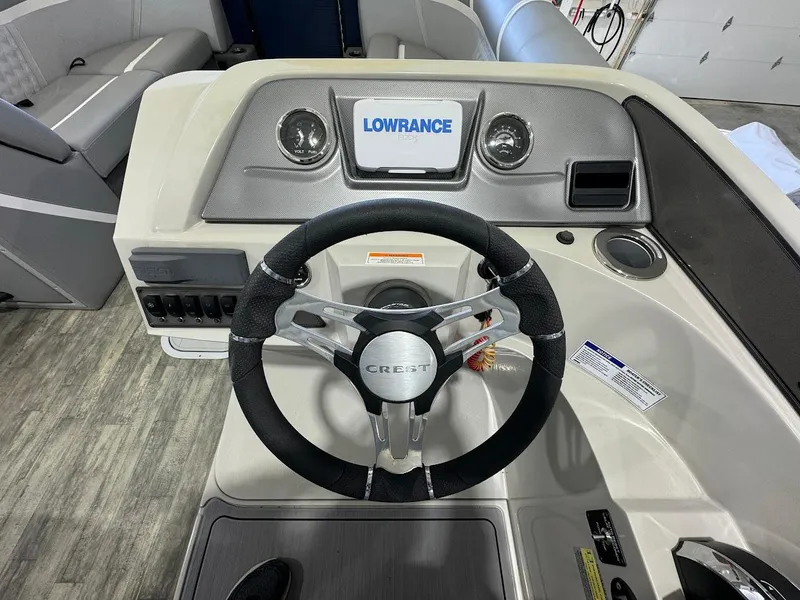 Slide: The Image of 2023 Crest Classic Platinum 220 dashboard with steering wheel and Lowrance display. - 8