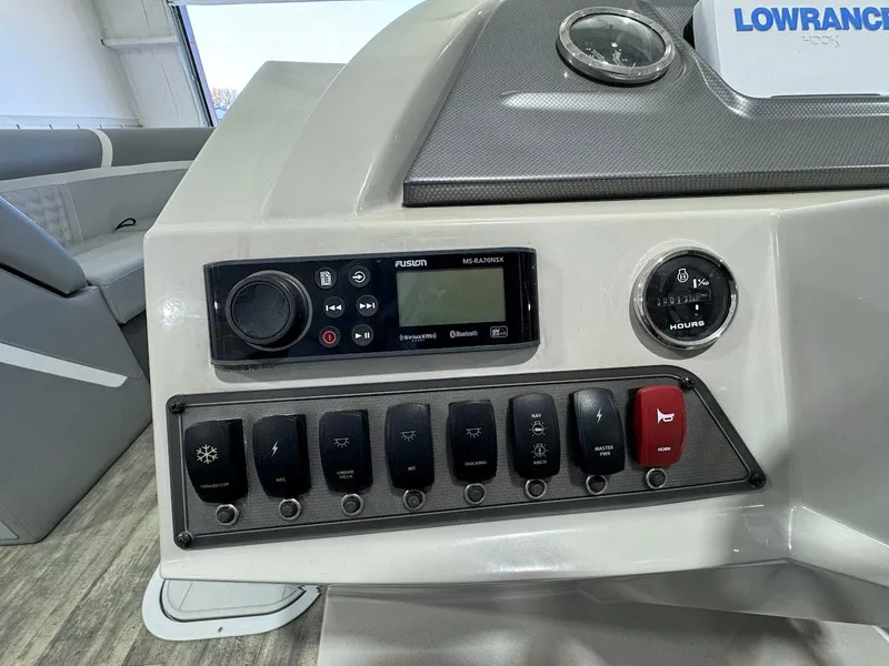 Slide: The Image of Control panel of 2023 Crest Classic Platinum 220 boat with switches and display. - 9