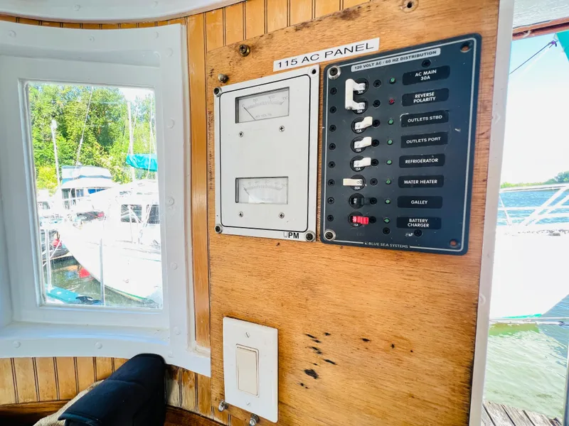 Slide: The Image of 1955 Colin Archer 42 boat interior with 115 AC panel and window view. - 11