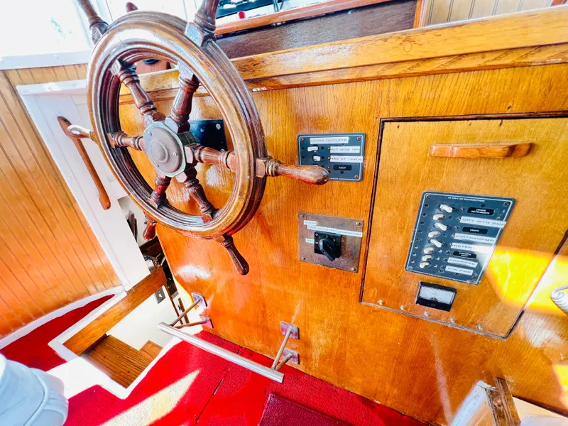 Slide: The Image of Vintage 1955 Colin Archer 42 boat helm with wooden wheel and control panels. - 16