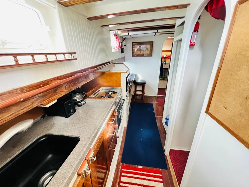 Slide: The Image of 1955 Colin Archer 42 yacht interior with galley kitchen and cozy living space. - 18