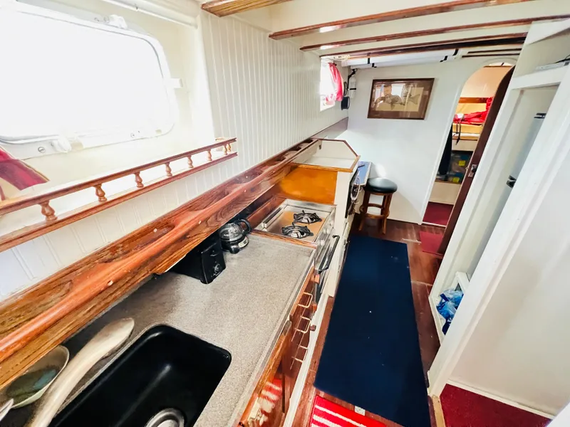 Slide: The Image of Interior of 1955 Colin Archer 42 sailboat with galley kitchen and wooden accents. - 19