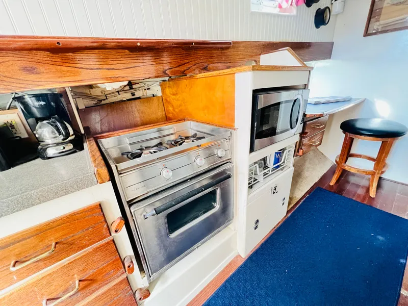 Slide: The Image of 1955 Colin Archer 42 boat kitchen with stove, microwave, and wooden cabinetry. - 20