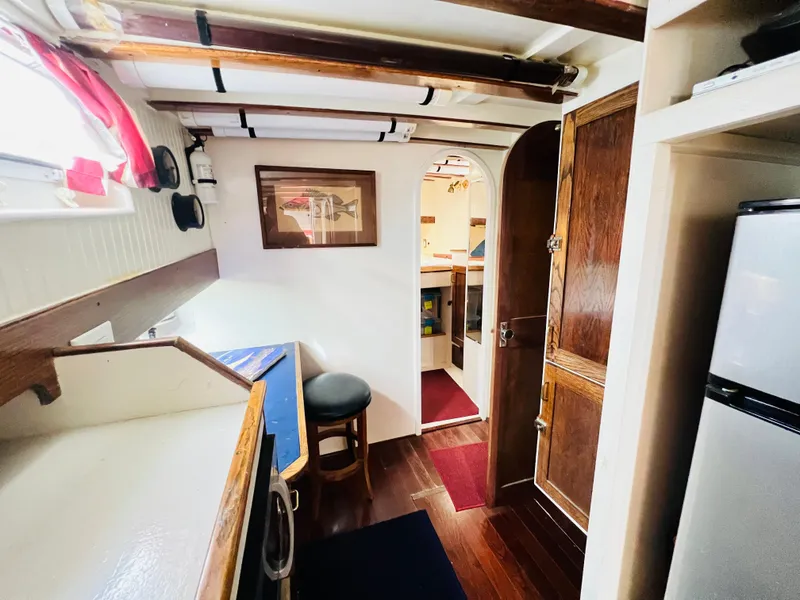 Slide: The Image of Interior of 1955 Colin Archer 42 sailboat with wooden finishes and compact kitchen. - 23