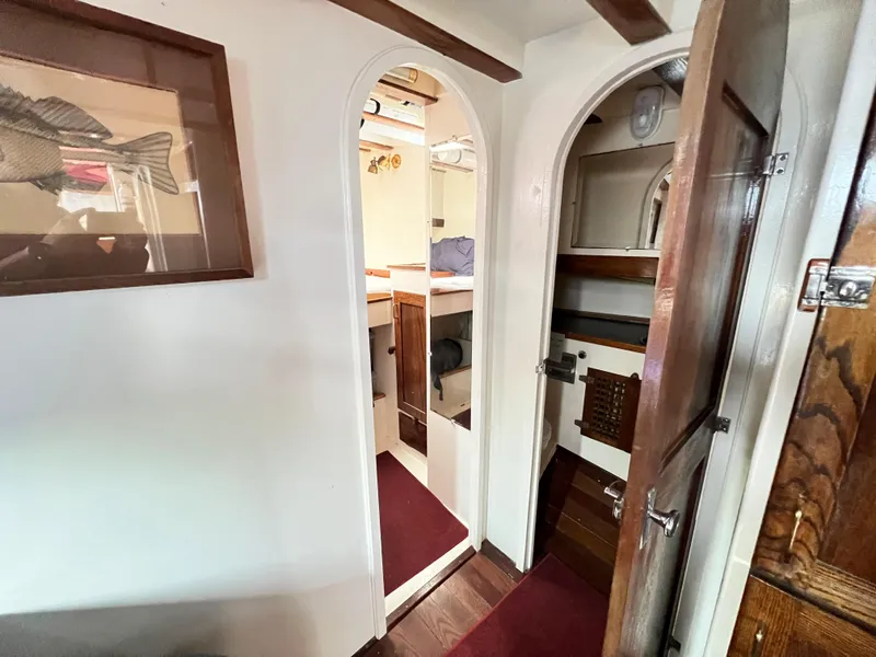 Slide: The Image of 1955 Colin Archer 42 interior with wooden doors and cozy cabin space. - 24