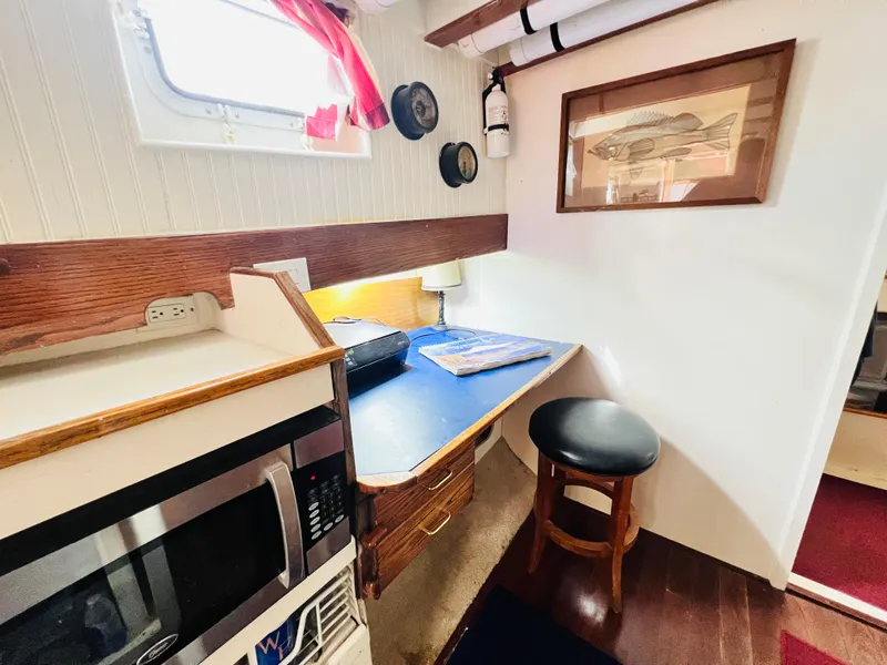 Slide: The Image of Cozy cabin interior of 1955 Colin Archer 42 sailboat with desk, microwave, and porthole window. - 25