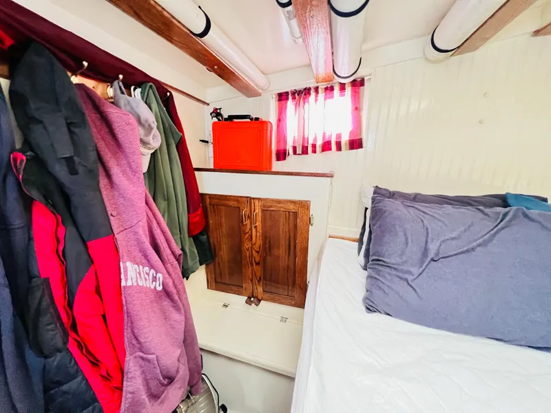 Slide: The Image of Cozy cabin interior of a 1955 Colin Archer 42 sailboat with bed and storage. - 28