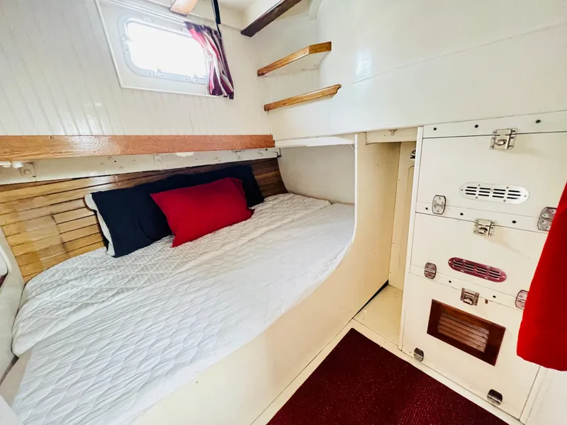 Slide: The Image of Cozy cabin interior of a 1955 Colin Archer 42 sailboat with bed and storage. - 30