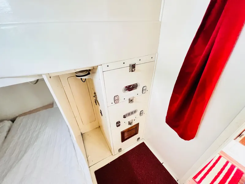 Slide: The Image of Interior of 1955 Colin Archer 42 sailboat with white cabinetry and red curtain. - 31