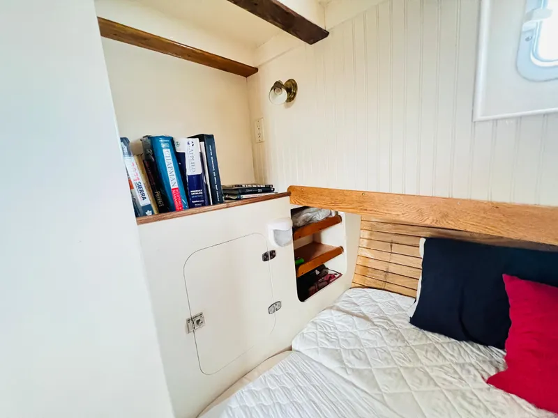 Slide: The Image of Cozy cabin interior of a 1955 Colin Archer 42 sailboat with bookshelf and bed. - 32