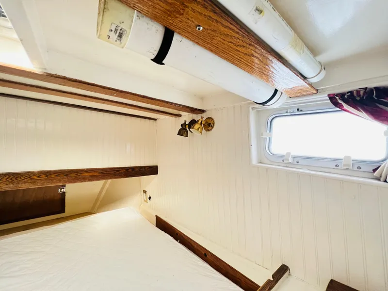 Slide: The Image of Interior cabin of a 1955 Colin Archer 42 sailboat with wooden beams and a porthole window. - 35