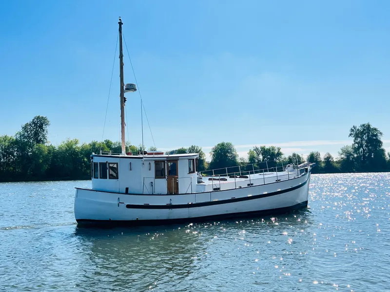 Slide: The Image of 1955 Colin Archer 42 boat on a sunny day, cruising on a calm river. - 37