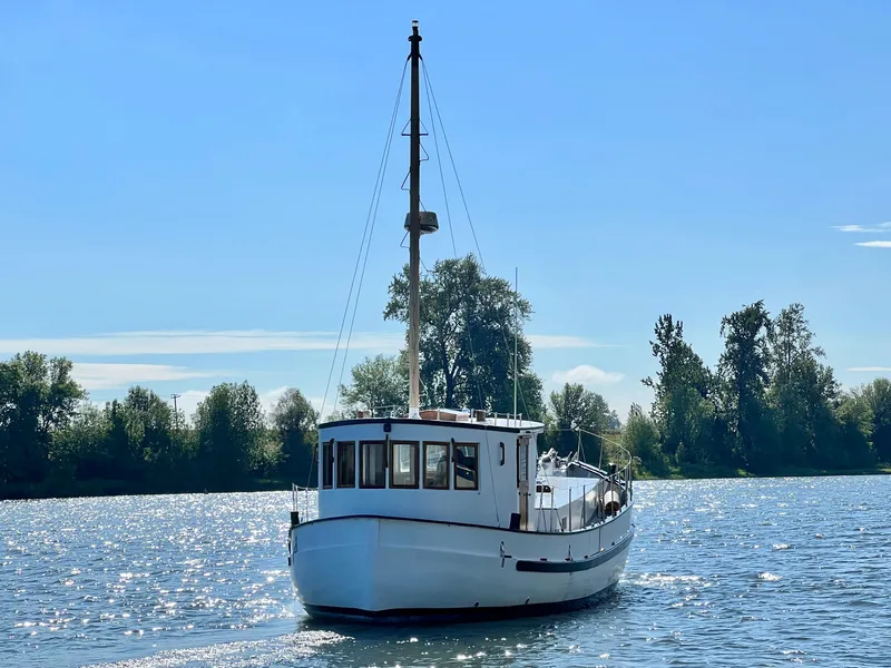 Slide: The Image of 1955 Colin Archer 42 boat sailing on a sunny day with trees in the background. - 38