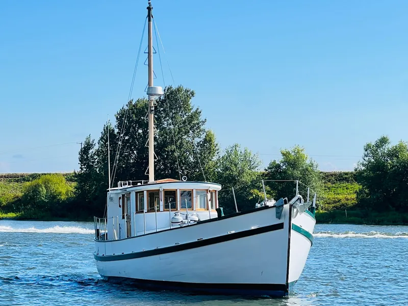 Slide: The Image of 1955 Colin Archer 42 boat cruising on a calm river. - 47