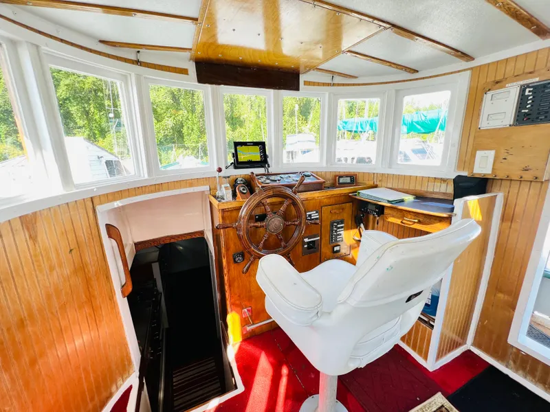 Slide: The Image of Helm station of a 1955 Colin Archer 42 boat with wooden interior and modern navigation equipment. - 6