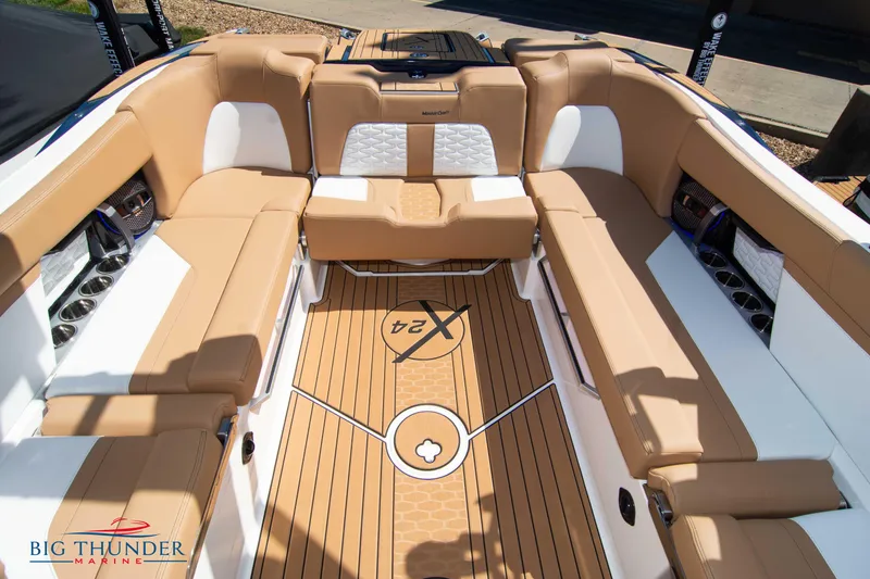 Slide: The Image of 2023 MasterCraft X24 boat interior with tan and white seating, Big Thunder Marine logo. - 27