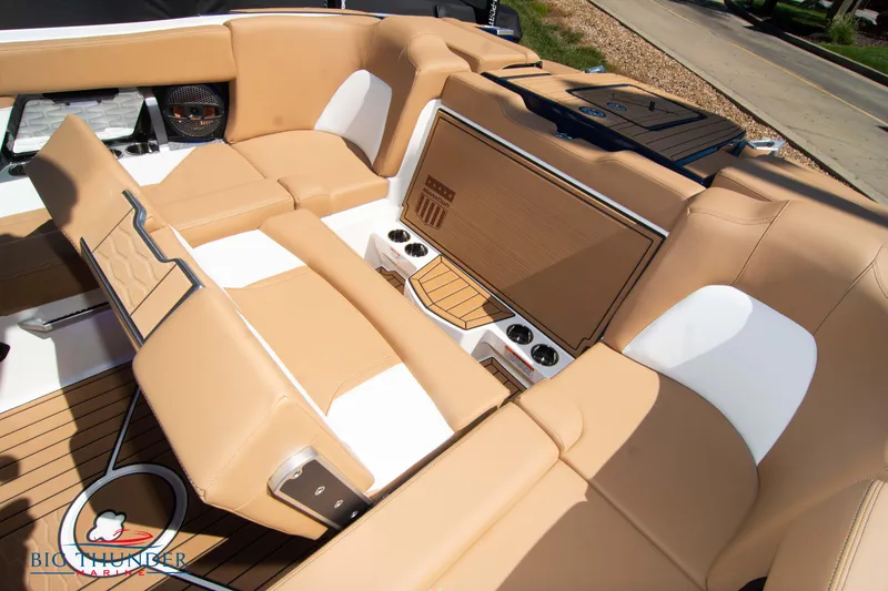 Slide: The Image of 2023 MasterCraft X24 boat interior with tan and white seating, premium audio system, and teak flooring. - 29