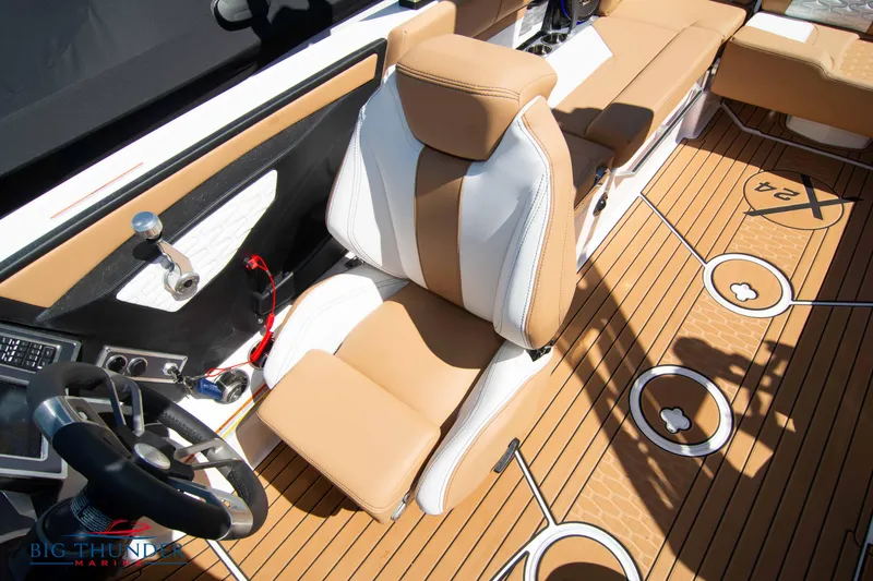 Slide: The Image of 2023 MasterCraft X24 boat interior with tan and white captain's seat and teak flooring. - 40