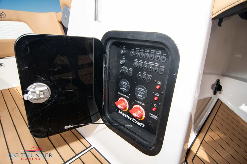 Slide: The Image of 2023 MasterCraft X24 control panel with switches and dials, open compartment door. - 44