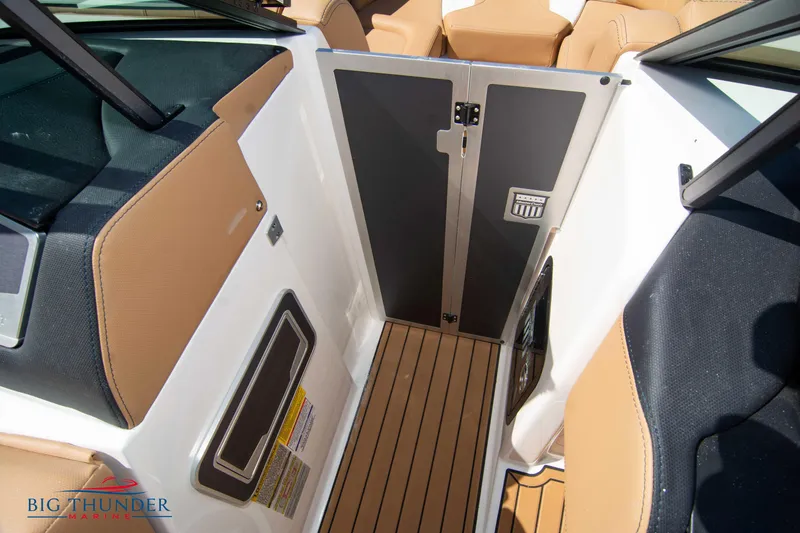 Slide: The Image of 2023 MasterCraft X24 boat interior with teak flooring and tan upholstery. - 45