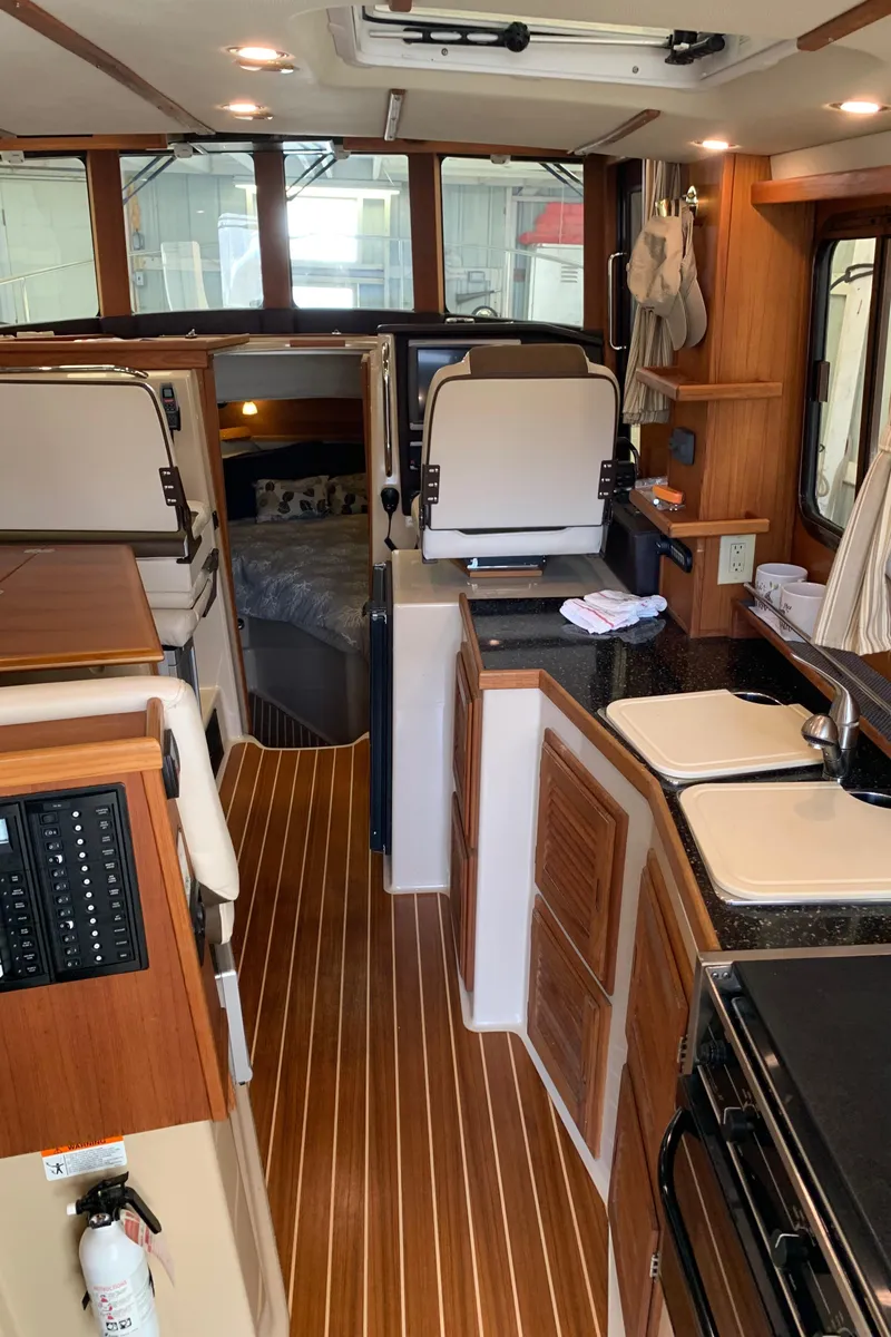 Slide: The Image of Interior of a 2014 Ranger Tugs Trawler with wood flooring and modern amenities. - 17