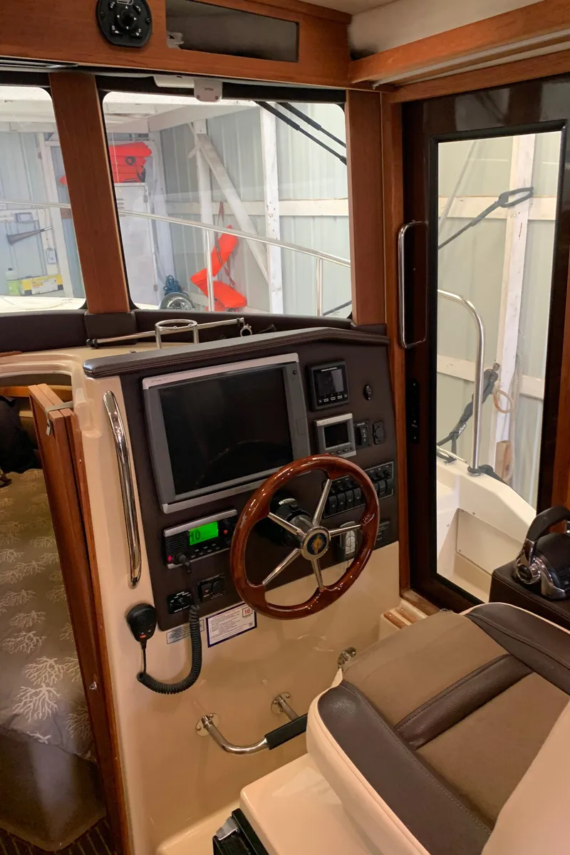 Slide: The Image of 2014 Ranger Tugs Trawler helm with navigation equipment and wooden steering wheel. - 23