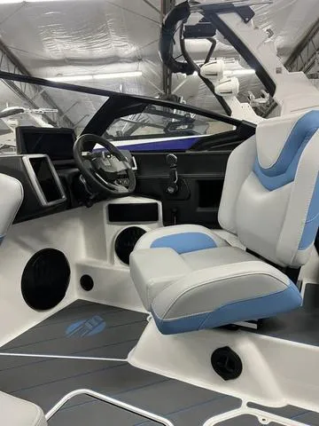 Slide: The Image of 2024 Malibu 22 LSV boat interior with modern dashboard and blue-accented seating. - 10