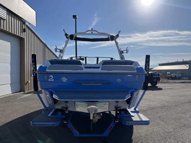 Slide: The Image of 2024 Malibu 22 LSV boat, rear view, blue exterior, parked outdoors. - 4