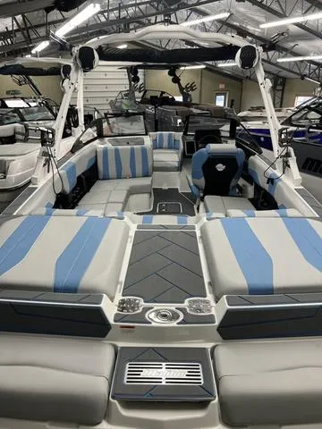 Slide: The Image of 2024 Malibu 22 LSV boat interior with blue and gray seating in showroom. - 5