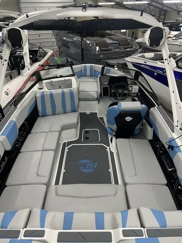 Slide: The Image of 2024 Malibu 22 LSV boat interior with blue and gray seating, modern dashboard. - 8